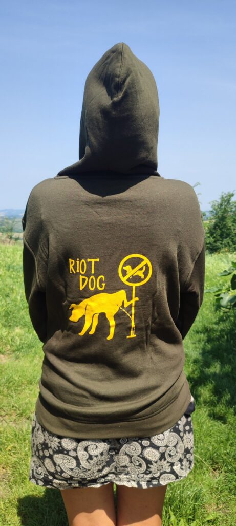 felpa di riot dog verde: sul retro, il disegno giallo di un cane che piscia sul cartello in cui c'è il simbolo "vietato ai cani" 